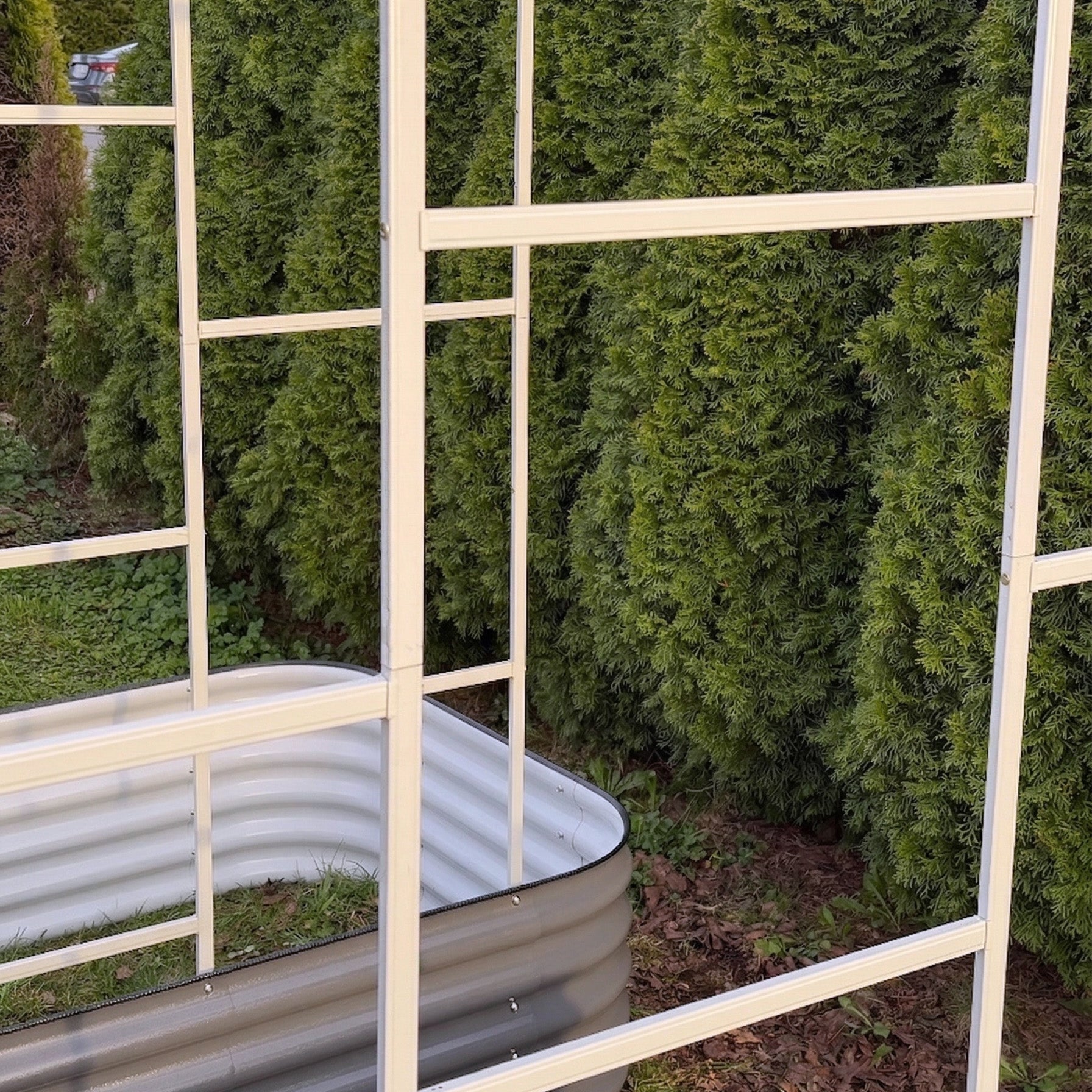 Arched trellis installed over raised garden bed with climbing vegetables